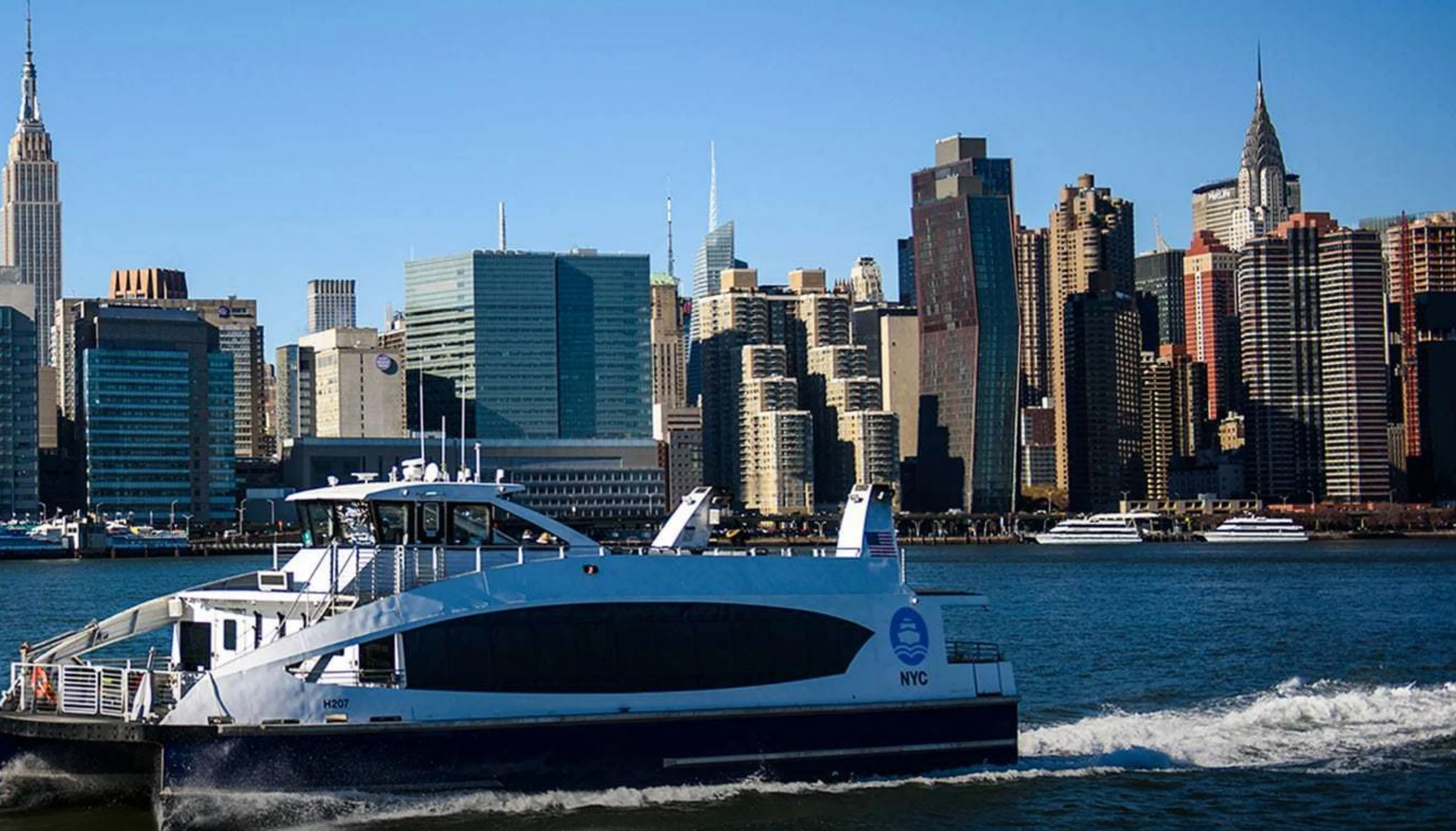 NYC Ferry vessel crossing the East River against the Manhattan skyline